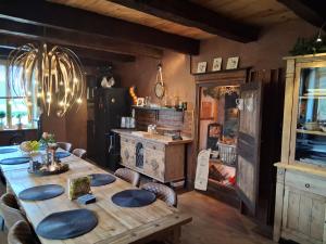 a dining room with a wooden table and a kitchen at B&B maison du Saint Cirque in Saint-Dau
