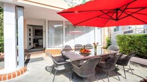 a table and chairs with a red umbrella on a patio at Ferienwohnung Vulkaneifel in Daun