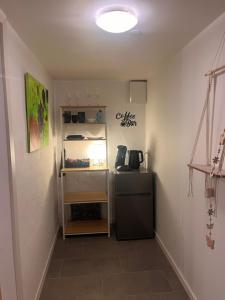 a room with a refrigerator and a shelf at Hygge i det grønne in Langå