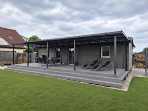 a house with a deck with chairs on it at Domeček u Prahy in Nupaky