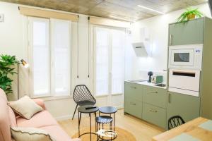a living room with a pink couch and a kitchen at BM Apartamentos in Ribadesella
