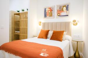 a bedroom with a bed with an orange blanket at BM Apartamentos in Ribadesella