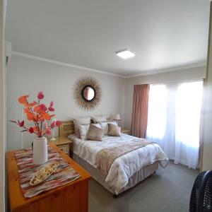 a bedroom with a bed with a table and a mirror at Heaven at Sea in Mossel Bay +43 photos