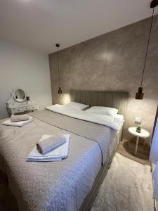 a bedroom with a large bed with two towels on it at Novi apartman Posušje in Posušje