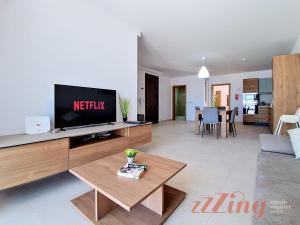 a living room with a flat screen tv on a entertainment center at Merhba Court Apartments - St Pauls Bay in St. Paul's Bay