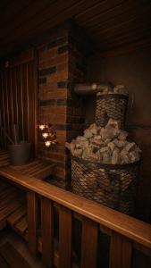a brick fireplace with a basket of fire wood at Pirts Rozēni in Saulkrasti