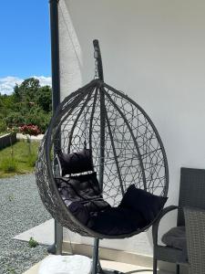 a hanging chair with two pillows in it at Novi apartman Posušje in Posušje