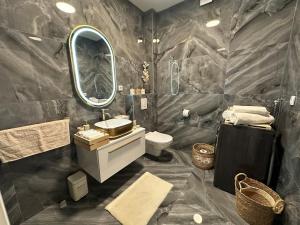 a bathroom with a sink and a toilet and a mirror at Novi apartman Posušje in Posušje +48 photos