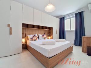 a bedroom with a large bed and blue curtains at Merhba Court Apartments - St Pauls Bay in St. Paul's Bay