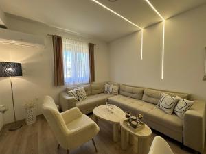 a living room with a couch and a table and chairs at Novi apartman Posušje in Posušje