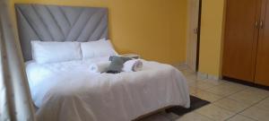a bed with towels and a stuffed animal on it at Abodes at 113 in Manzini