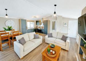 a living room with two white couches and a table at Bosworth Lakeside Lodges in Carlton