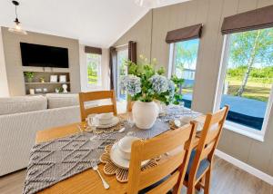 a dining room with a table and chairs and a couch at Bosworth Lakeside Lodges in Carlton