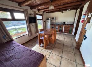 a room with a kitchen and a table and a bed at Cabañas Luna Lunera in Tandil