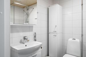 a white bathroom with a sink and a toilet at Hiisi Homes Turku Ratapiha in Turku +76 photos