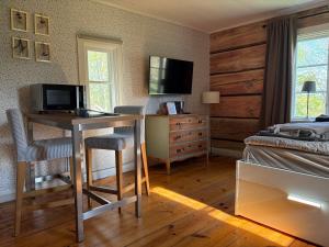 a bedroom with a desk with a television and a bed at Drängstugan - Tiny House in Johannesberg