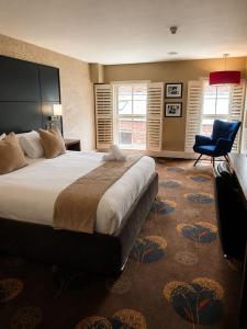 a bedroom with a large bed and a blue chair at Queens Hotel Belfast in Belfast +54 photos
