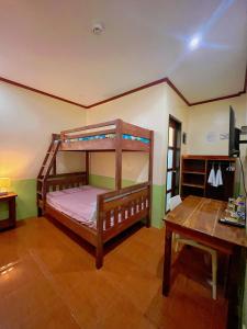 a bedroom with two bunk beds and a table at Marianne's Guest House in New Agutaya