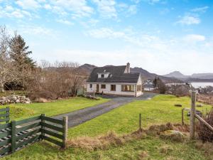 a house on a hill with a fence at Bramble Cottage in Gairloch