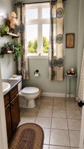 a bathroom with a toilet and a window at Shediac Beach Suite- Pointe du Chene Wharf and Parlee Beach in Pointe-du-Chêne +19 photos