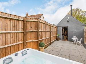 a backyard with a wooden fence and a tub at Barwick Lodge in Bawdeswell