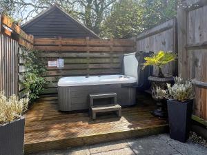 a bath tub sitting on a wooden deck at Barwick Lodge in Bawdeswell