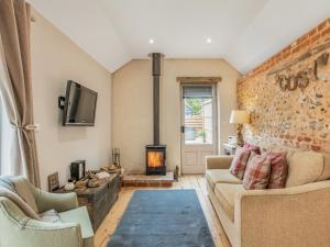 a living room with a couch and a fireplace at Barwick Lodge in Bawdeswell +7 photos