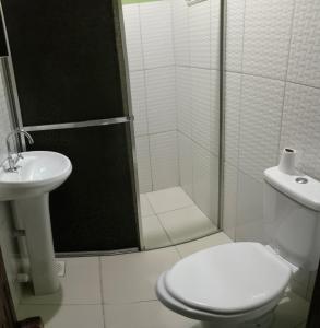 a bathroom with a shower and a toilet and a sink at Caju Hostel in Alter do Chao