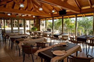 a restaurant with tables and chairs in a room with windows at Villa La Font Apart Hotel & Spa in Villa Carlos Paz
