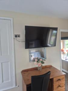 a room with a wooden desk with a television on the wall at ACCOMADATION WREXHAM in Wrexham +47 photos