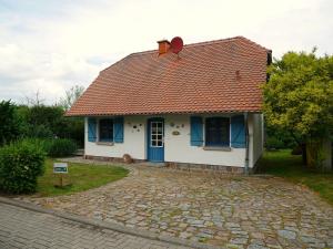 a small white house with a red roof at Poeler Inselhaus in Kaltenhof