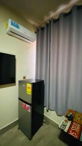a small refrigerator in a room with a window at Simon donkor 2 in Kumasi