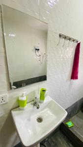 a bathroom with a white sink and a mirror at Simon donkor 2 in Kumasi