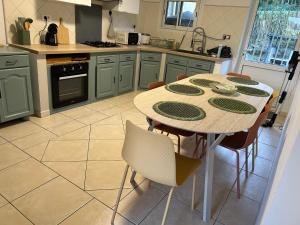 a kitchen with a table and chairs in a kitchen at La Villa Nature in La Plaine des Cafres +7 photos