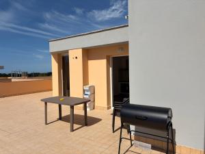 a patio with a table and chairs in front of a building at Attico Terracotta in Borgo Bainsizza