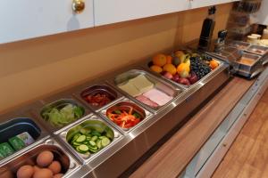 a buffet filled with different types of fruits and vegetables at Apartments Kopecna with garage parking possible in Brno +121 photos