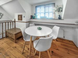 a dining room with a white table and chairs at The Flat The Farm in Godstone