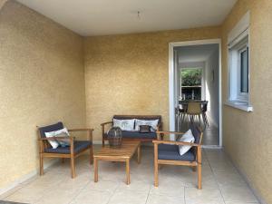 a patio with two chairs and a table and a couch at La Villa Nature in La Plaine des Cafres