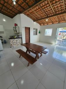 a wooden table and a bench in a room at Descanso das Águas in Santo Amaro