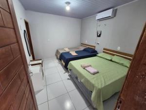 a room with two beds and a door in it at Descanso das Águas in Santo Amaro +16 photos