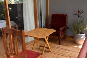 a wooden table and a chair in a room at Camphor Mountain View in Lushoto