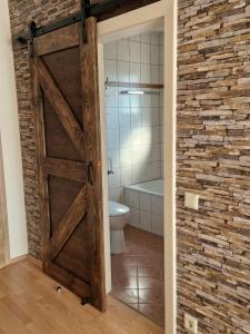 a bathroom with a wooden door and a toilet at Waldpension Schiefling am See in Schiefling am See +39 photos