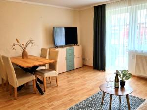 a living room with a dining table and a television at Waldpension Schiefling am See in Schiefling am See