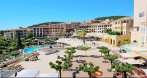 a resort with a pool and trees and buildings at Cocon dans le village cap esterel in Saint-Raphaël
