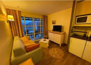 a living room with a couch and a kitchen at Cocon dans le village cap esterel in Saint-Raphaël
