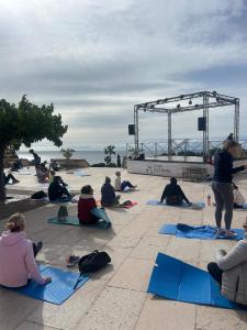 a group of people sitting on the ground doing yoga at Cocon dans le village cap esterel in Saint-Raphaël