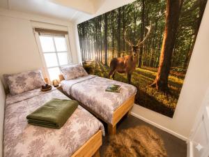 a bedroom with two beds and a painting of a deer at Villa Mar veluwe in Ermelo