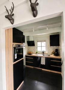 a kitchen with black cabinets and antlers on the wall at Villa Mar veluwe in Ermelo +34 photos