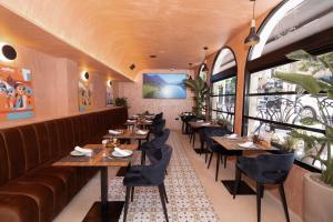 a restaurant with tables and chairs and a couch at Hotel Dimora 1927 in Tirana