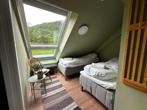a small room with two beds and a window at Hauane Bed and Breakfast in Sandnes
